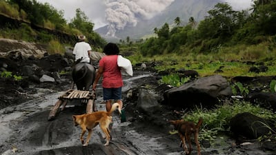 Filipino villagers walk along the slopes of rumbling Mayon Volcano as it spews ash in Legaspi city, Albay province, Philippines. Francis R. Malasig / EPA