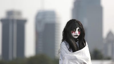 A street performer dressed up as a traditional Indonesian ghost popularly known as ‘kuntilanak’, waits for tourists to pose for a photo with him for a small tip, in Jakarta, Indonesia. Dita Alangkara / AP Photo
