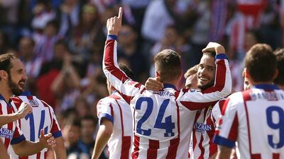 Mario Suarez, centre, celebrates scoring one of Atletico Madrid's goals in a 2-0 win over Espanyol in La Liga on Sunday in Madrid. Juan Medina / Reuters / October 19, 2014