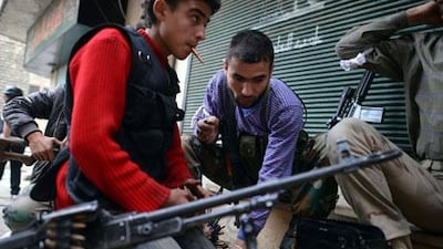 Syrian rebel fighters load weapons in the Sheikh Maqsud neighborhood in Aleppo last week. Syrian rebels say they have been told access to weapons from Arabian Gulf states will be conditional on their pledging allegiance to the Free Syrian Army and its civilian overseers in the Syrian National Coalition. Dimitar Dilkoff / AFP