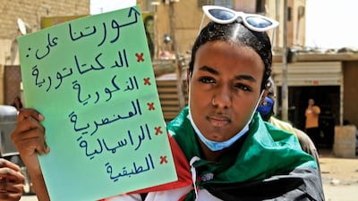 A woman holds a placard that reads 'Our revolution is against dictatorship, masculinity, racism, capitalism and classism' during a rally marking International Women's Day in Sudan's capital Khartoum. AFP