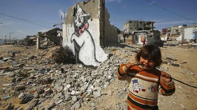 A Palestinian girl on February 26 looks on as a mural of a playful-looking kitten, presumably painted by British street artist Banksy, is seen on the remains of a house that witnesses said was destroyed by Israeli shelling during a 50-day war last summer, in Biet Hanoun in the northern Gaza Strip. Suhaib Salem / Reuters