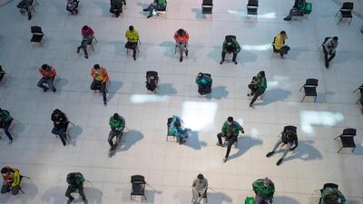 People practice social distancing as they sit on chairs spread apart in a waiting area for take-away food orders at a shopping mall in hopes of preventing the spread of the coronavirus in Bangkok, Thailand. AP Photo