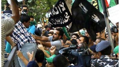 Supporters of the Islamist movement (R), who were demonstrating against the Syrian regime, clash with supporters of Syrian President Bashar al-Assad during their respective protests outside the Syrian embassy in Beirut on August 11, 2011. AFP PHOTO/STR