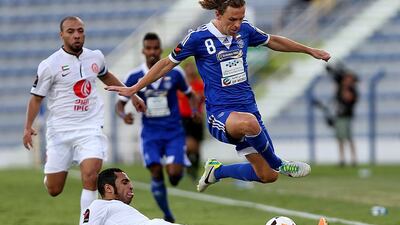 Al Nasr's Brett Holman, right, and Musallem Fayez of Al Jazira battle for possession during their Arabian Gulf League match at the Al Nasr Stadium in Dubai on Thursday. Satish Kumar / The National