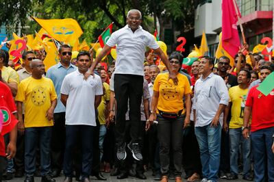 Maldives' opposition presidential candidate Ibrahim Mohamed Solih, center, jumps as he walks in a street march with supporters in Male, Maldives. AP