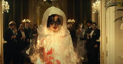 Emma Stone's 'Cruella' character sets alight a white cape to reveal a striking red dress in the newly released trailer. Courtesy Disney
