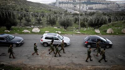 Jewish settlement of Har Homa is seen in the background as Israeli soldiers walk next to the convoy of Pierbattista Pizzaballa, the acting Latin Patriarch of Jerusalem. Reuters