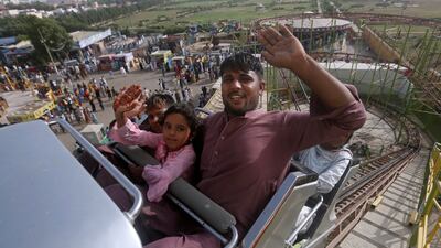 A family at a fun fair during the Eid Al Fitr holiday, marking the end of Ramadan, in Karachi, Pakistan. AP