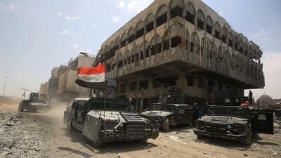 Members of the Iraqi federal police vehicles are seen in the Old City of Mosul on July 8, 2017, as their part of the battle has been declared accomplished, while other forces continue to fight Islamic State (IS) jihadists in the city. / AFP PHOTO / AHMAD AL-RUBAYE