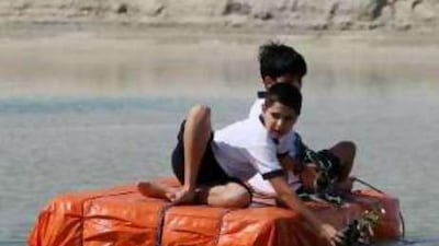 Pupils from the American International School in Abu Dhabi use a raft to plant mangrove trees at an environment reserve in Ghantoot.