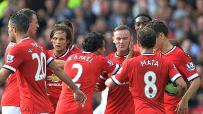 Manchester United's Wayne Rooney, centre, is congratulated by termmates after scoring their third goal in a 4-0 win over QPR in the EPL on Sunday. Peter Powell / EPA