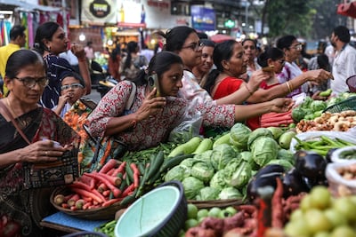 People buy vegetables at a market in Mumbai, India. In many countries recurring shocks – including inflation – can disrupt access to food, health and livelihoods. EPA