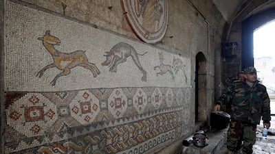 A Syrian army soldier walks past a mosaic inside the damaged museum of Maarat al-Numan, Syria. Reuters