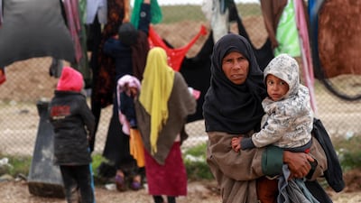 A Syrian woman carries her child inside an internallly displaced persons camp in the north-east of the country. AFP