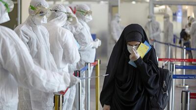 Medical staff check passengers returning from Iran at Najaf International Airport. AFP