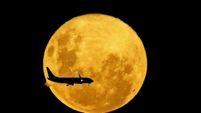 A plane passes in front of the full moon as seen from Curitiba, Brazil. AFP
