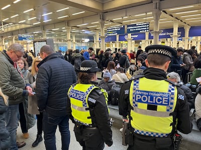 British Transport Police officers watch as passengers wait at the Eurostar entrance in St Pancras International station, London. PA