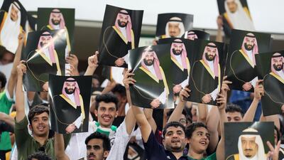 Saudi Arabia fans cheer as they hold up pictures of Saudi King Salman and Saudi Crown Prince and Minister of Defense Mohammed bin Salman during the 2018 World Cup group B qualifying soccer match between Saudi Arabia and Japan in Jiddah, Saudi Arabia, Tuesday, Sept. 5, 2017. Saudi Arabia won 1-0. (AP Photo)