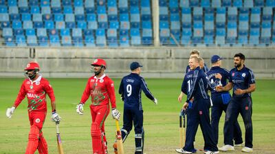 Scotland players celebrate victory as Oman batters leave the field inn Dubai. Photo: ICC