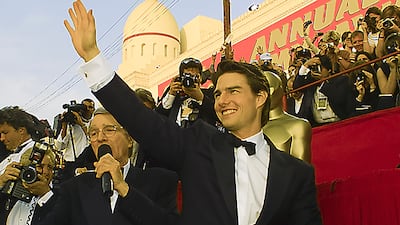 Tom Cruise, whose film Top Gun: Maverick is nominated for Best Picture at the 2023 awards, waves to fans on the red carpet at the 1997 ceremony