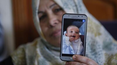 The grandmother of Palestinian baby Omar Yagi displays a picture of him in Gaza City after he died, unable to travel to Israel for life-saving heart surgery. AFP