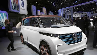 A worker polishes an electric concept car at the VW stand. Many major car makers are using the Paris show, held in a city whose mayor wants to ban diesels to reduce pollution, as the venue to show off new zero-emission electric cars. Michel Euler / AP