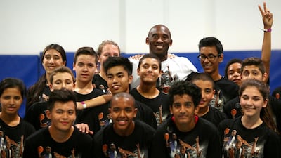 LA Lakers NBA player Kobe Bryant (C) poses for group photo after a training session at the Gems American Academy in Abu Dhabi on September, 26, 2013. Bryant arrived for a Health and Fitness Weekend, to promote awareness of diabetes in the United Arab Emirates in his first trip to a Middle East country. AFP