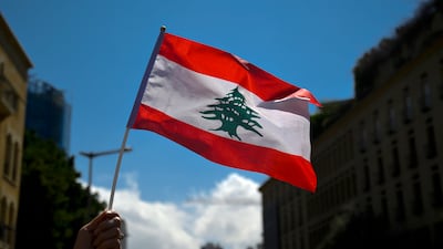 A bank customer holds a Lebanese flag during a protest in Beirut on April 13, 2022. Customers were demanding that they be allowed to withdraw deposits that were blocked amid the country's economic crisis. EPA