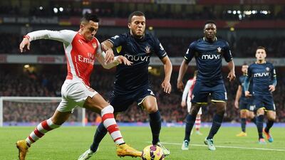 Arsenal's Alexis Sanchez dribbles past Southampton defender Ryan Bertrand during his side's 1-0 Premier League victory on Wednesday. Andy Rain / EPA / December 3, 2014