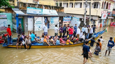 A boat proves the best mode of transport along a flooded street in Vijayawada. AFP