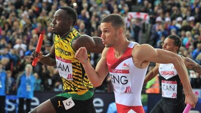 Jamaica's Usain Bolt runs next to England's Danny Talbot after taking the handoff in the 4x100-metre relay at the Commonwealth Games on Saturday. Glyn Kirk / AFP