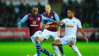 Aston Villa's Fabian Delph, left, is challenged by Wayne Routledge of Swansea during their Premier League match at Liberty Stadium on December 26, 2014 in Swansea, Wales. (Photo by Stu Forster/Getty Images)