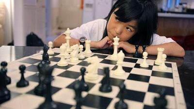 Nine year old Carissa Yip waits for her father, Percy, to make a move during a chess match. Julia Malakie / AP Photo