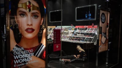 A woman is lying on the ground of a shop after being beaten by a policeman during clashes in downtown Barcelona. AP Photo