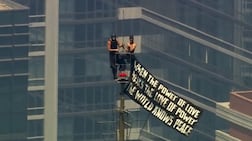 Angela Nikolau and Ivan Beerkus climbed the Empire State Building's antenna on Wednesday and unfurled a banner. Reuters