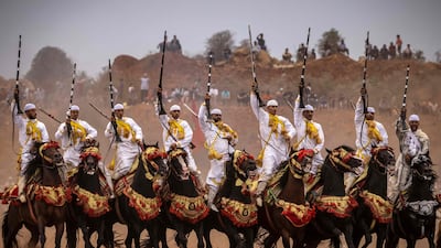 Moroccan horsemen raise their rifles during a traditional horse riding performance at a Moussem culture and heritage festival in the capital Rabat, on August 27, 2022. (Photo by FADEL SENNA / AFP)