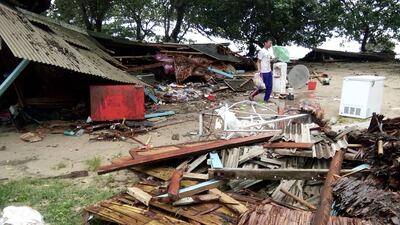 A man looks for salvageable items from a damaged home on Carita beach. AFP