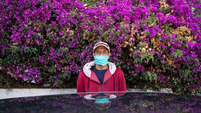 Ibrahim, a parking attendant, poses for a photo in his face mask during the coronavirus pandemic in Rabat, Morocco. AP