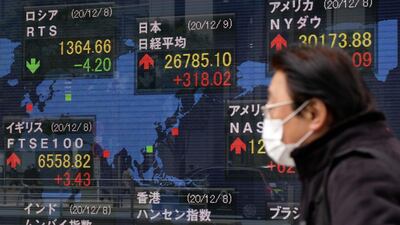 A pedestrian walks past an electric quotation board displaying share prices on the Tokyo Stock Exchange. Robo-advisor WealthNavi debuted on the bourse Tuesday in one of the biggest initial public offerings on the exchange this year. AFP