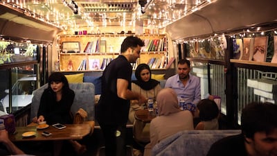 People drink coffee at "The Bus Cafe Erbil" in Erbil, the capital of Iraq's Kurdish autonomous region on the long weekend of the Eid al-Fitr holiday. AFP