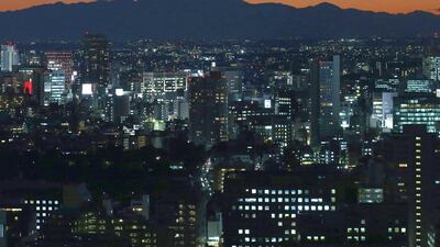 The silhouette of Japan's Mount Fuji is seen beyond buildings in Tokyo. Wage growth has not kept pace with price rises, so a key mechanism of Abenomics is not working yet. Toru Hanai / Reuters