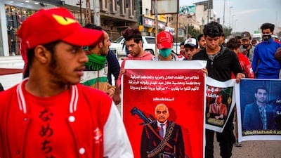 A protester holds up a banner depicting Iraqi Prime Minister Adel Abdel Mahdi as a sniper with a caption above in Arabic reading "we demand the fair and honest judiciary and the international courts to try and hold accountable Adel Abdel Mahdi and his mercenary forces for unjustly killing almost 700 innocent Iraqis", during an anti-government demonstration, also calling for freedom of the press, in the southern Iraqi city of Basra. AFP