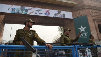 Pakistani policemen stand guard at an entrance of the Gaddafi Cricket Stadium. Aamir Qureshi / AFP