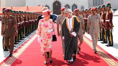 Britain’s Queen Elizabeth II walks with the ruler of Oman, Sultan Qaboos bin Said, as she leaves the sultunate from Muscat.