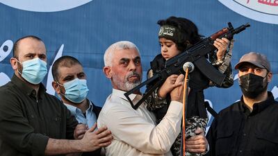 Yahya Sinwar holds the child of a Hamas fighter, who was killed in fighting with Israel, during Gaza City rally in 2021. Mr Sinwar is on the run from Israeli forces, calling into question the practicalities of negotiating effectively with such a clandestine figure. AFP