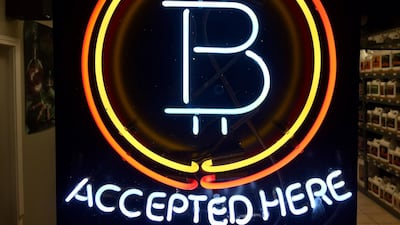 A neon sign hanging in the window of a store that shows that the business accepts bitcoin as payment. Gillian Flaccus/AP