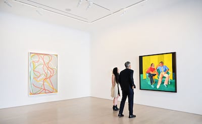 Alex Marshall, senior specialist and senior vice president at Christie's, views 'The Conversation' by David Hockney displayed beside 'The Attended' by Brice Marden during the media preview of Paul Allen's art Collection. AFP
