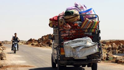 A man rides on a motorbike near a truck loaded with belongings in Deraa countryside, Syria June 22, 2018. REUTERS/Alaa al-Faqir