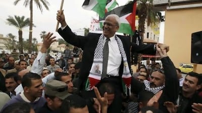 Saeb Erekat, the Palestinian Authority's chief negotiator, is carried during a rally upon his return from Cairo to Jericho in January this year. Mr Erekat initially accused Al Jazeera of misrepresenting quotes and making up others in its coverage of "The Palestine Papers", its name for what it says are leaked documents showing the Palestinians giving way on major issues in talks with Israel. Ammar Awad / Reuters